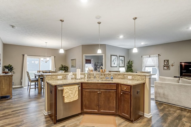 kitchen featuring dishwasher, pendant lighting, sink, and a center island with sink