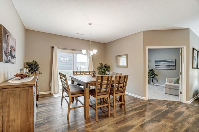 dining room with dark hardwood / wood-style floors and a notable chandelier