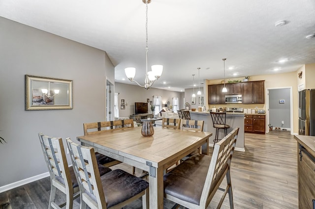 dining space featuring an inviting chandelier and dark hardwood / wood-style floors