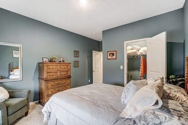 carpeted bedroom featuring a walk in closet and a closet