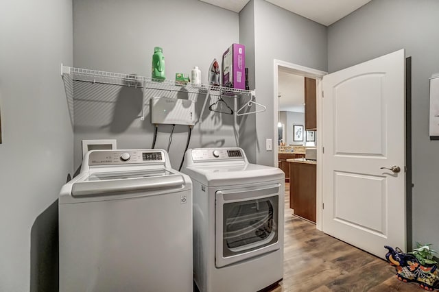 laundry area with hardwood / wood-style floors and washing machine and dryer