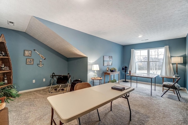 carpeted office featuring vaulted ceiling and a textured ceiling