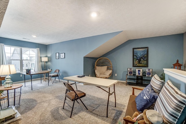 carpeted home office featuring vaulted ceiling and a textured ceiling