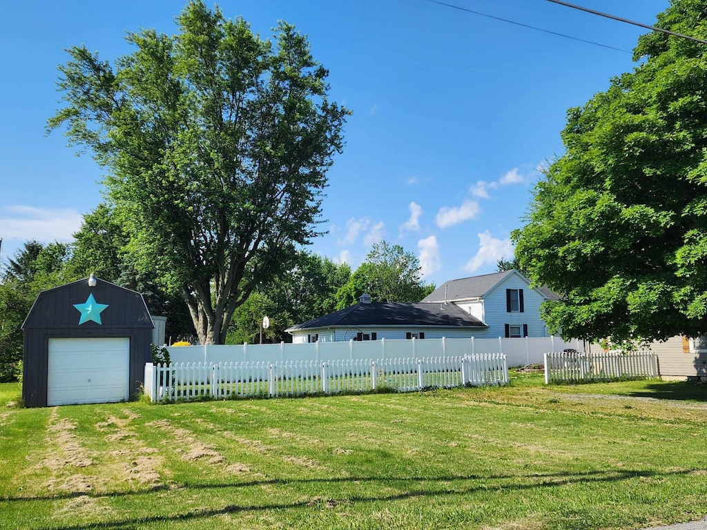 view of yard featuring a garage and an outdoor structure