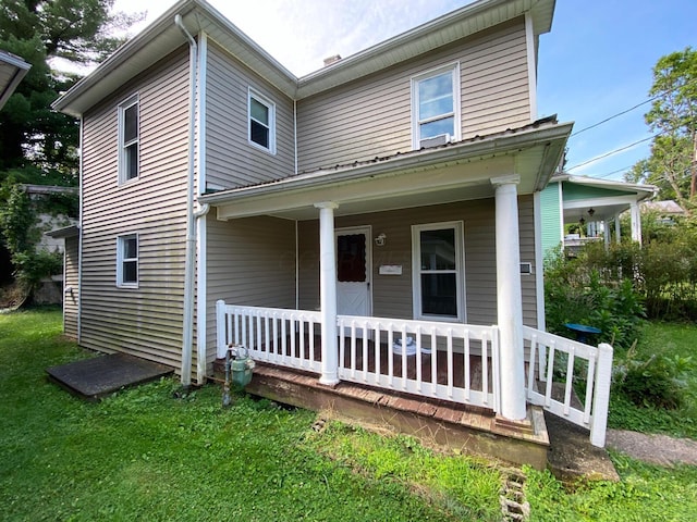 view of front of property featuring covered porch and a front yard