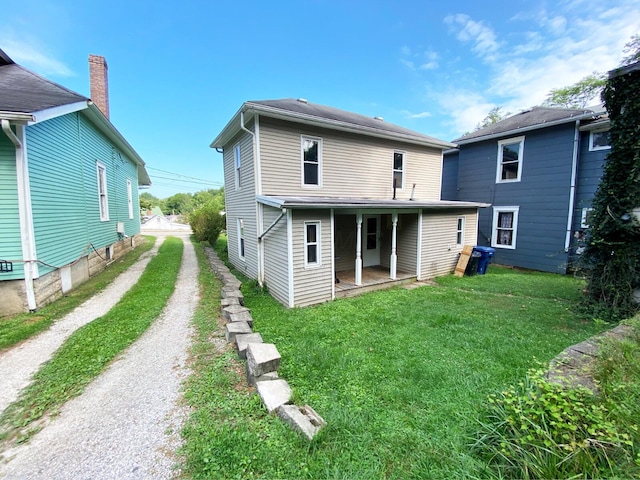 rear view of house featuring a lawn