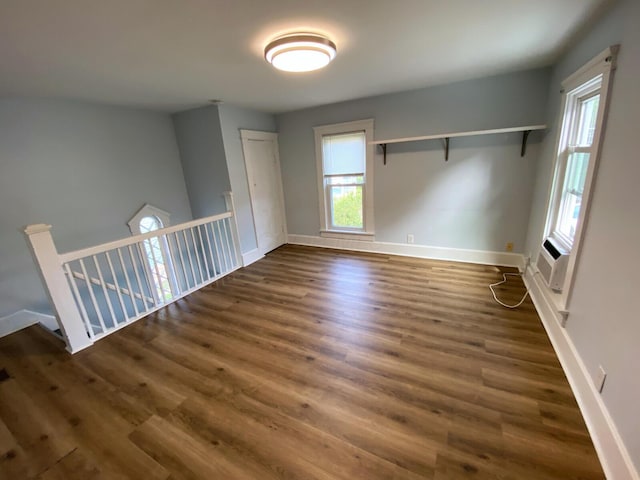 unfurnished room featuring a healthy amount of sunlight and dark hardwood / wood-style floors