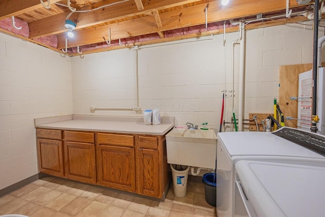 clothes washing area featuring sink, cabinets, and washing machine and clothes dryer