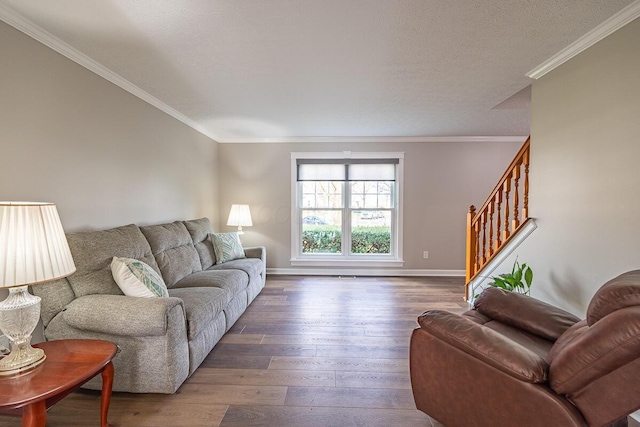 living room with dark wood-type flooring, ornamental molding, and a textured ceiling