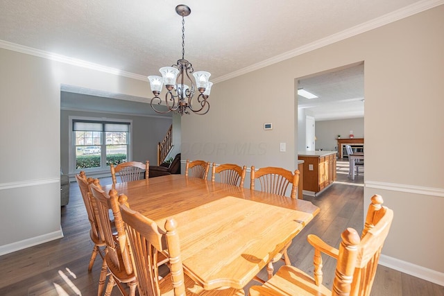 dining space featuring ornamental molding, an inviting chandelier, a textured ceiling, and dark hardwood / wood-style flooring