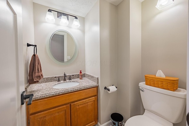 bathroom featuring vanity, a textured ceiling, and toilet