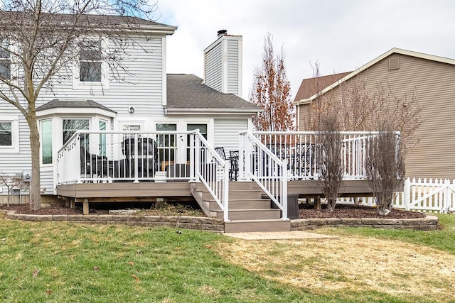 rear view of house with a deck and a lawn