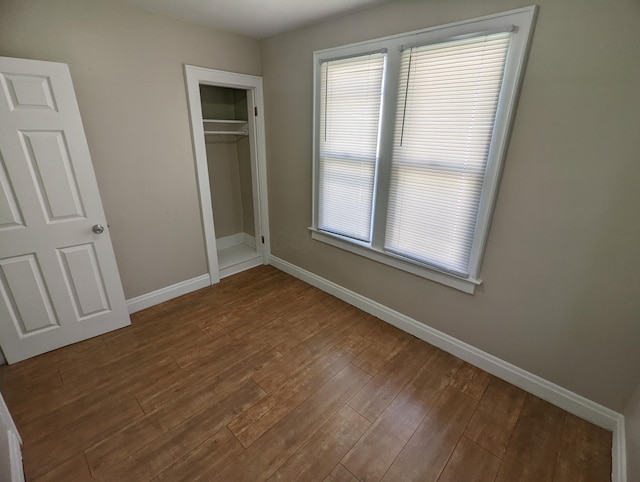 unfurnished bedroom with wood-type flooring and a closet