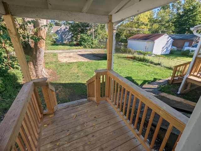 wooden terrace featuring an outdoor structure and a yard