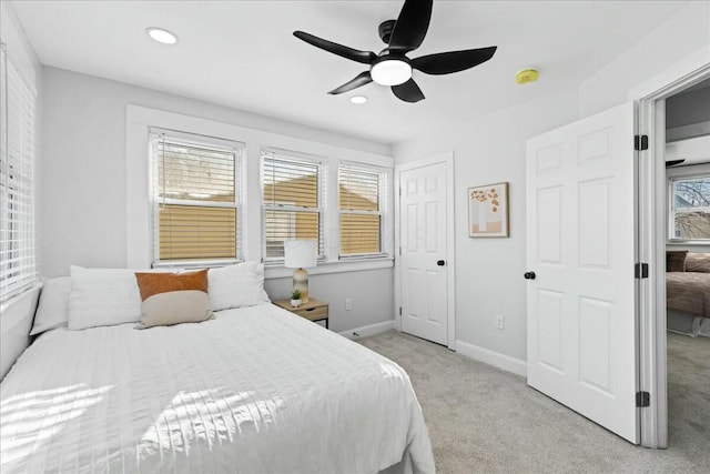 carpeted bedroom with ceiling fan and a closet