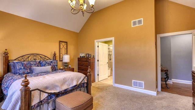 bedroom featuring a notable chandelier, light colored carpet, high vaulted ceiling, and ensuite bathroom