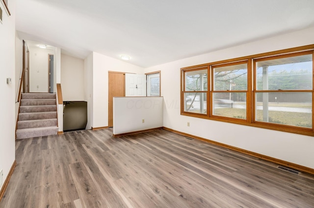 unfurnished living room featuring lofted ceiling and hardwood / wood-style flooring