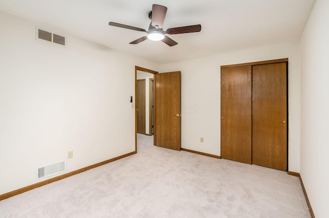 unfurnished bedroom featuring light colored carpet, a closet, and ceiling fan