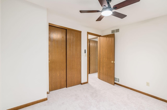 unfurnished bedroom with light colored carpet, ceiling fan, and a closet