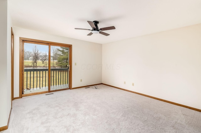 carpeted spare room featuring ceiling fan