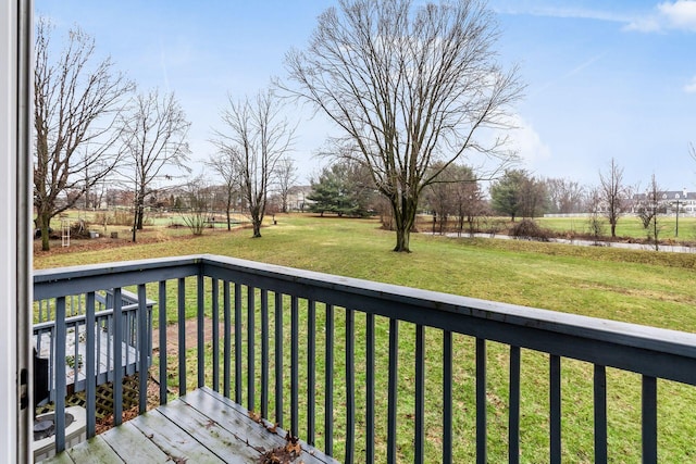 wooden deck featuring a lawn