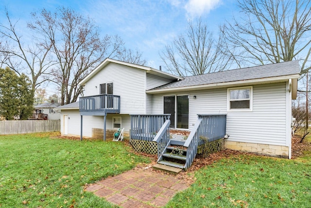 rear view of house featuring a lawn and a deck