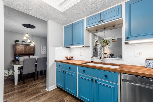 kitchen with butcher block counters, blue cabinetry, and dishwasher