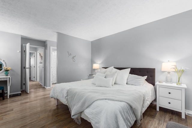 bedroom featuring dark hardwood / wood-style flooring and a textured ceiling