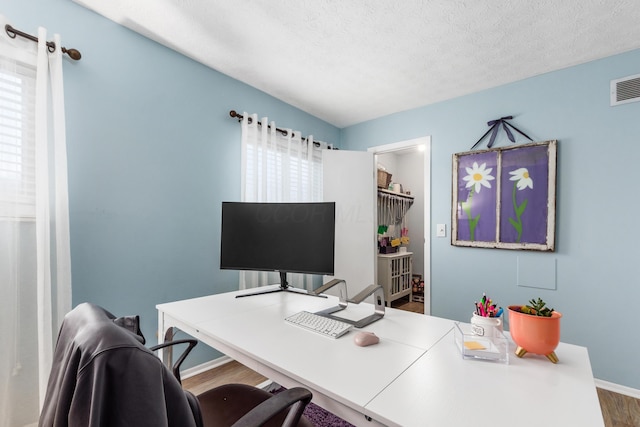 office area with wood-type flooring and a textured ceiling