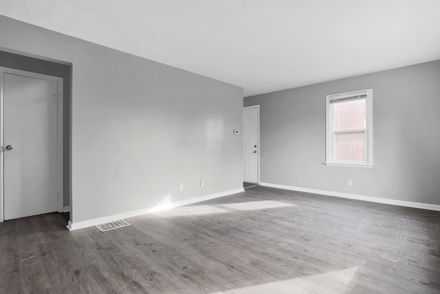 spare room with dark hardwood / wood-style floors