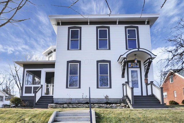 view of front of house featuring a front lawn and a sunroom