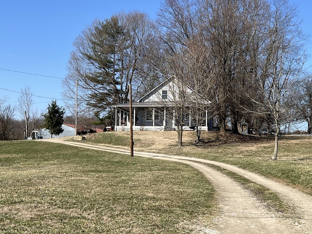 view of front of property featuring a front yard, a porch, and driveway