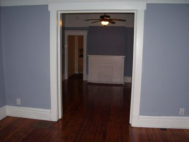 corridor with baseboards and hardwood / wood-style flooring