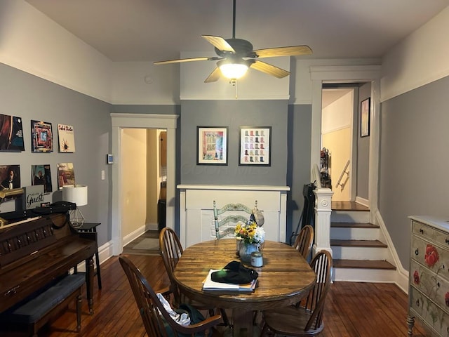 dining space with ceiling fan, baseboards, dark wood-style floors, and stairs