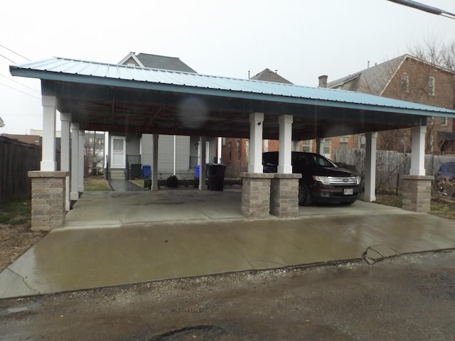 view of vehicle parking featuring a carport and fence