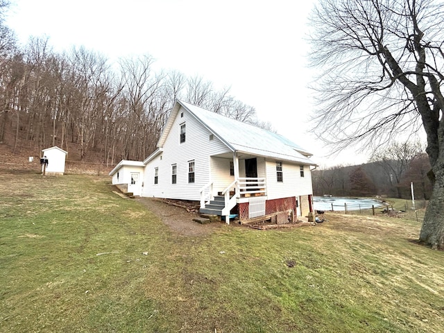 view of home's exterior featuring a pool, a shed, and a lawn