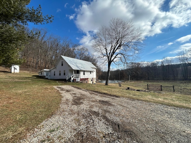 view of front of home featuring a storage unit and a front yard