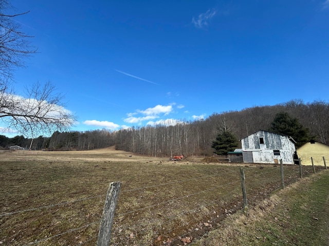 view of yard featuring a rural view and an outdoor structure