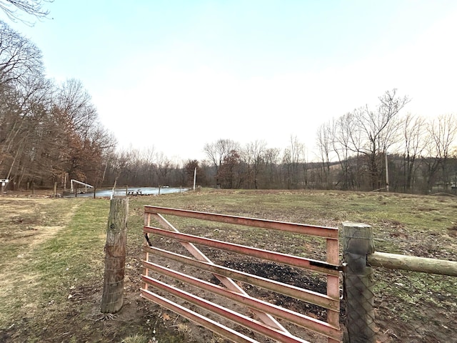 view of gate featuring a rural view, a yard, and a water view