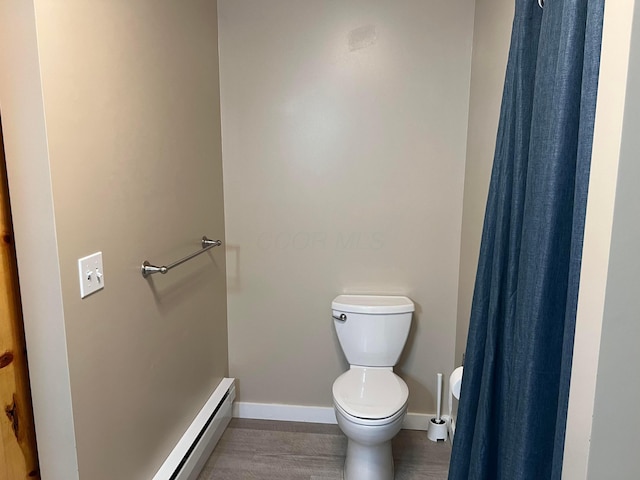 bathroom featuring a baseboard heating unit and toilet