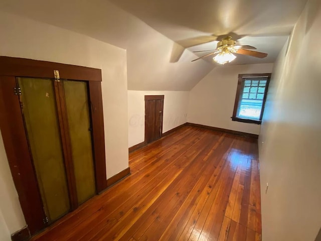 additional living space featuring vaulted ceiling, dark wood-type flooring, and ceiling fan