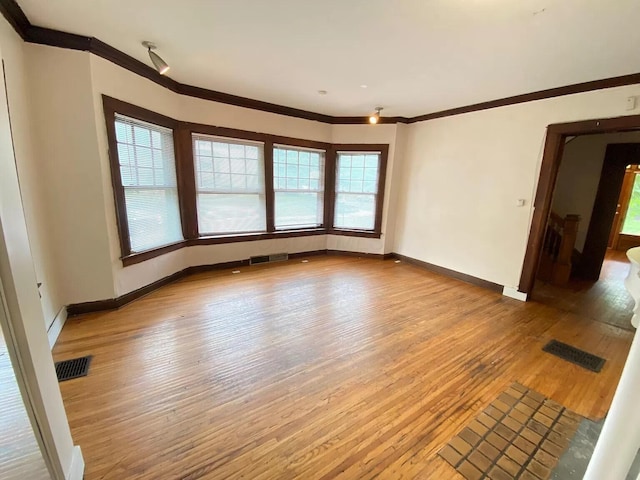 unfurnished room featuring wood-type flooring and ornamental molding