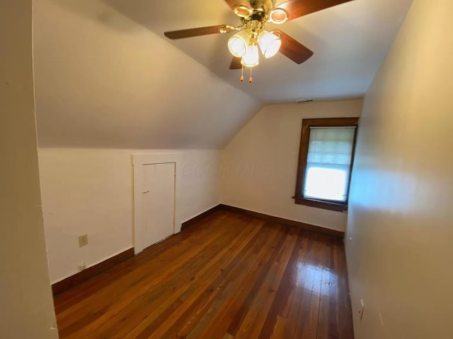 additional living space with lofted ceiling, dark hardwood / wood-style flooring, and ceiling fan