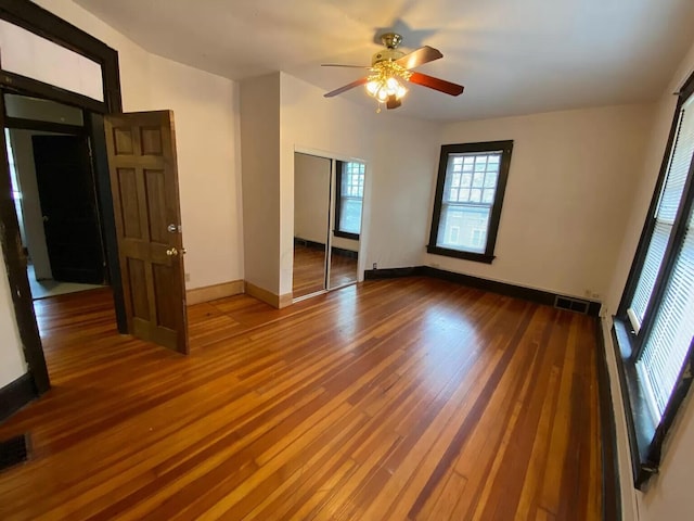 empty room with hardwood / wood-style floors and ceiling fan