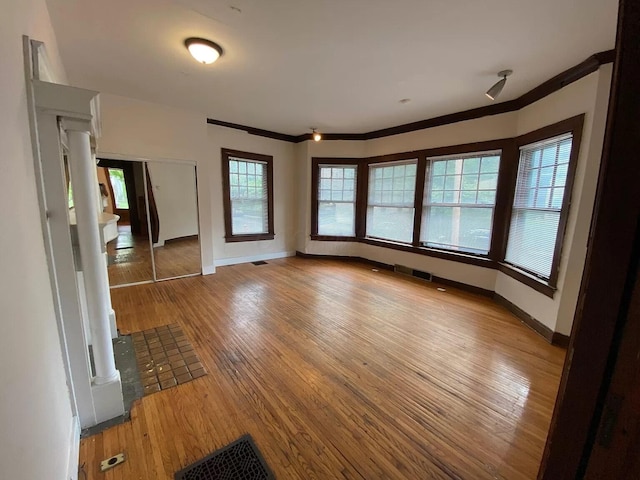 spare room with wood-type flooring and ornamental molding