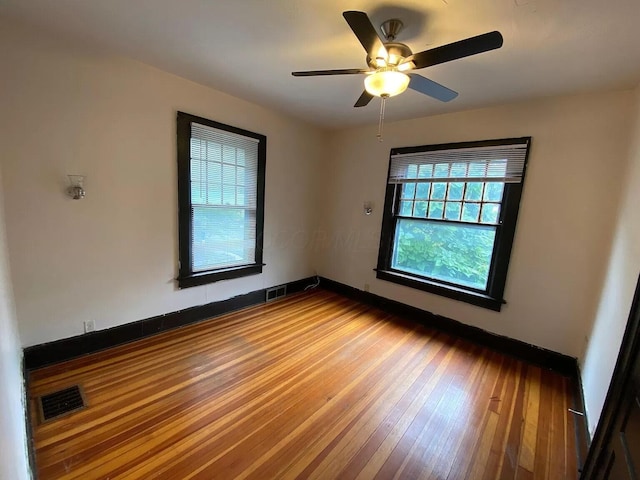 spare room with hardwood / wood-style floors and ceiling fan