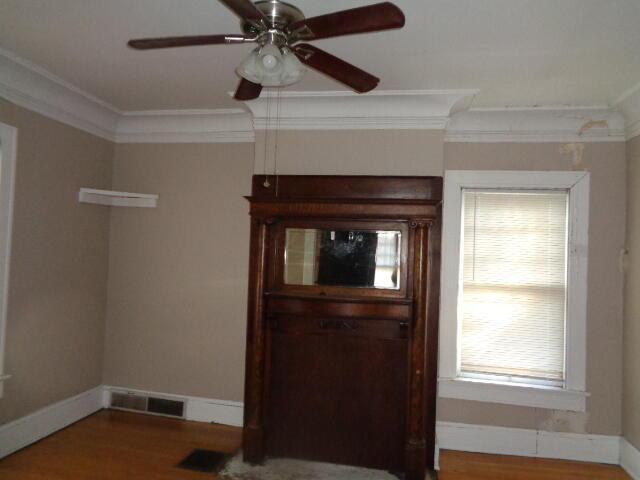 foyer entrance with crown molding, hardwood / wood-style floors, and ceiling fan