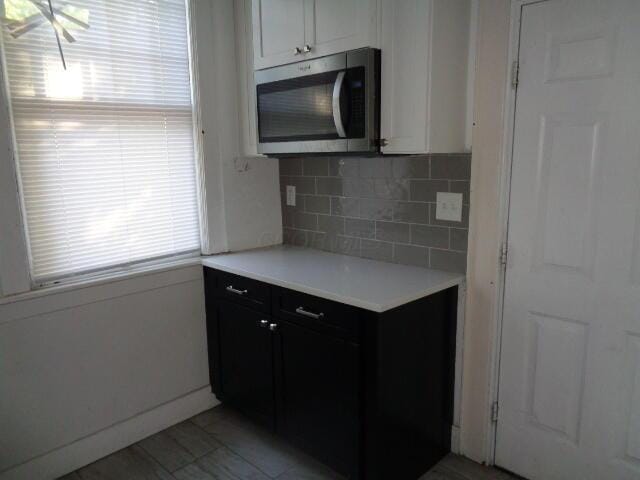 kitchen featuring tasteful backsplash and white cabinets