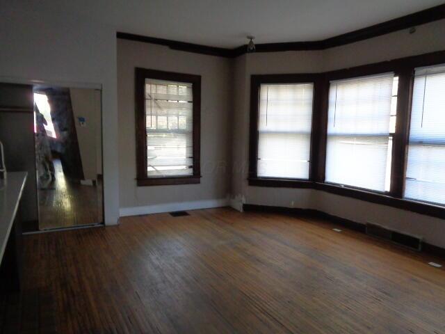 unfurnished dining area with a healthy amount of sunlight and dark hardwood / wood-style flooring