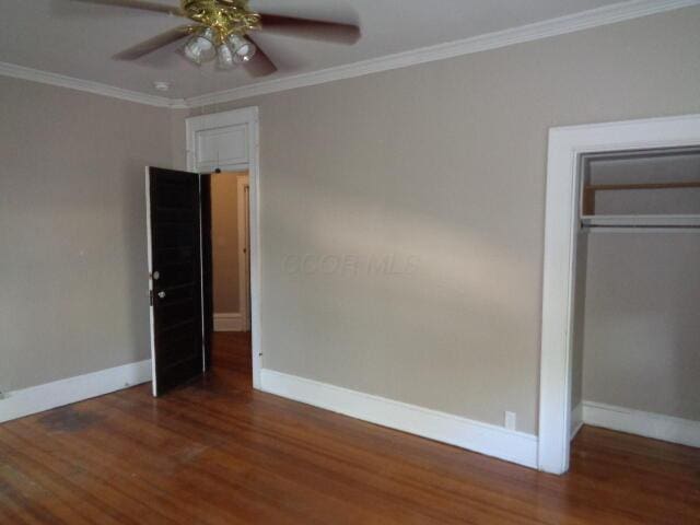 unfurnished bedroom with dark hardwood / wood-style flooring, crown molding, a closet, and ceiling fan